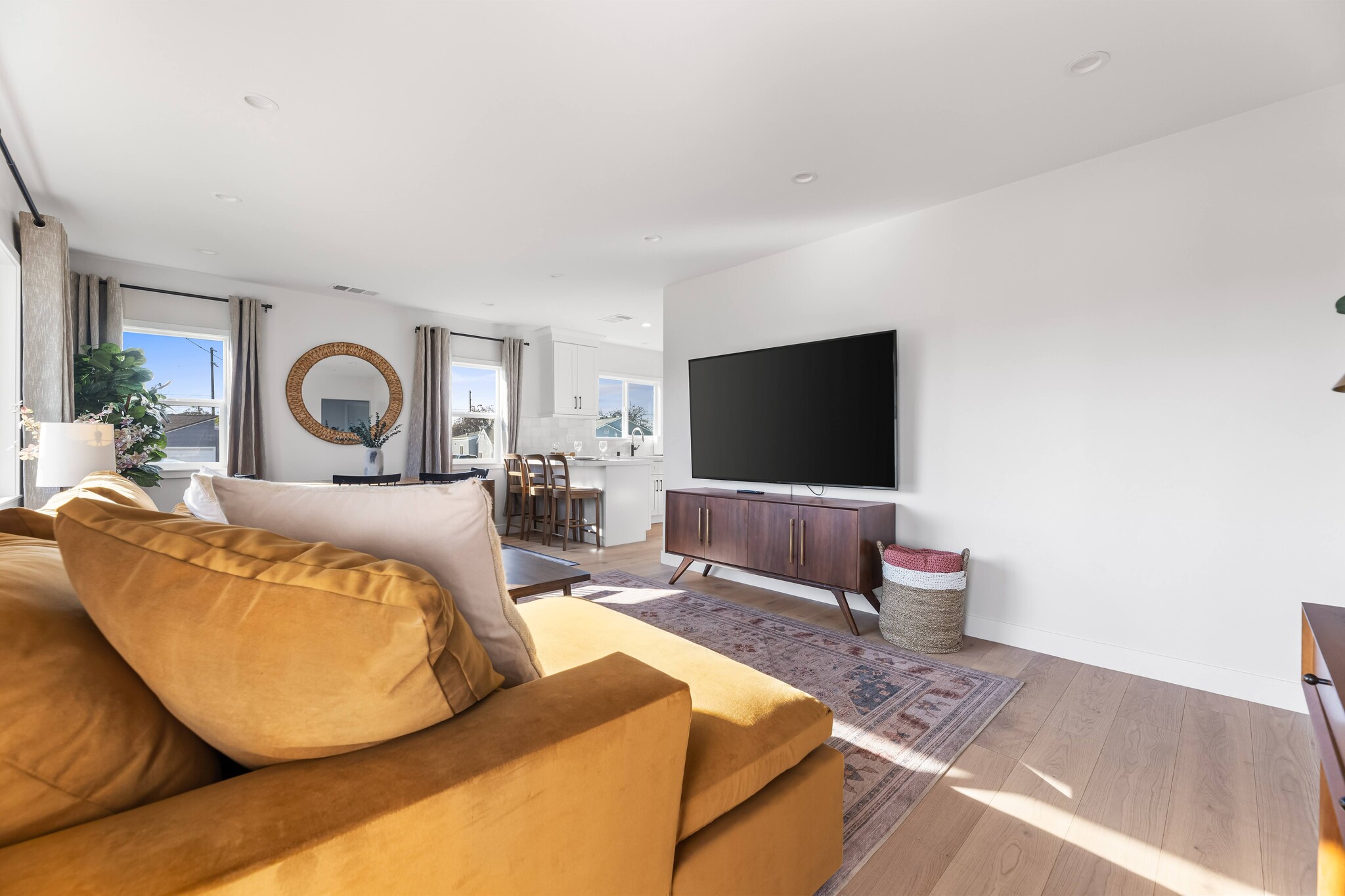 Living room with West Elm furniture, natural sunlight, and large TV flatscreen. - 1823 N Ditman Ave