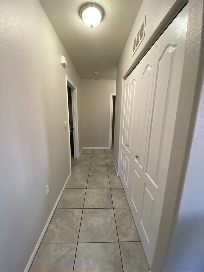 Building Photo - BEAUTIFUL CONDO IN A GATED COMMUNITY FEATURING PLANTATION SHUTTERS, TILE FLOORING AND NEW PAINT T...