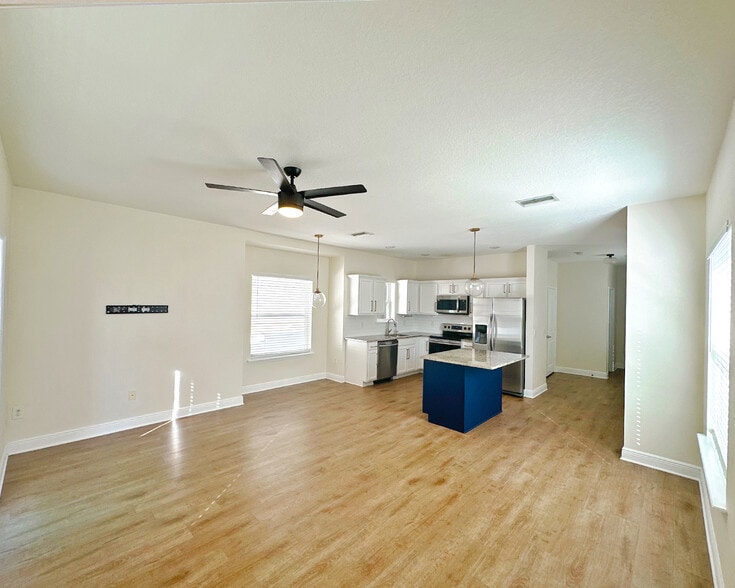 Spacious open-concept living area with natural light, hard floors, and open kitchen. - 1736 W Walnut St