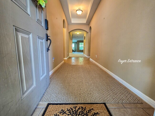 light-filled foyer adorned with tile floors and a modern chandelier - 301 Silver Trl