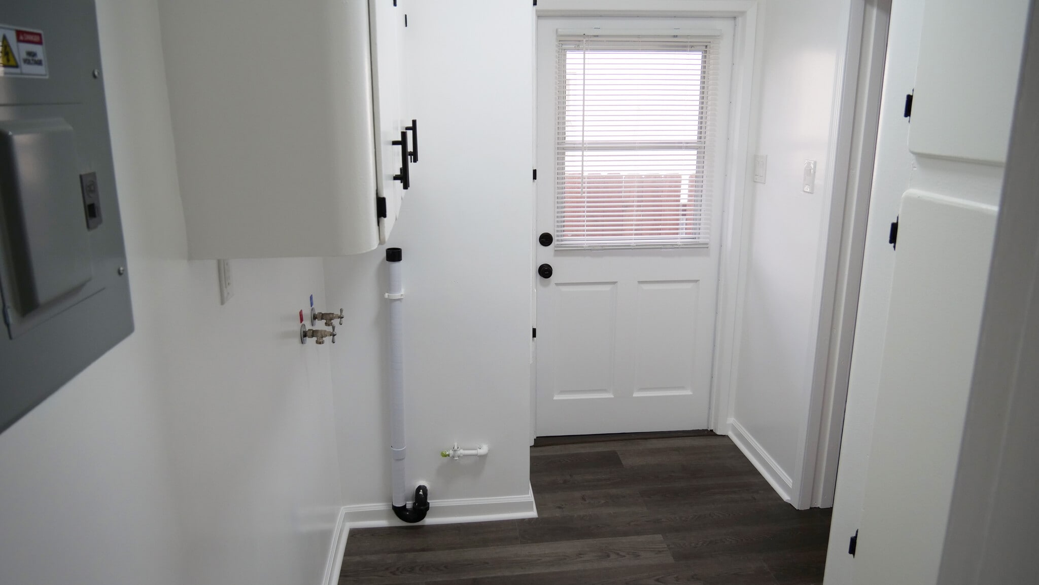 View of the laundry room from the hallway. Back door leading to your private backyard. - 259 E Puente St