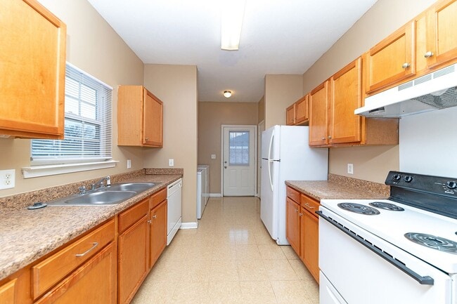 Kitchen with white appliances, wooden cabinetry, and generous counterspace - Lakeview Subdivision