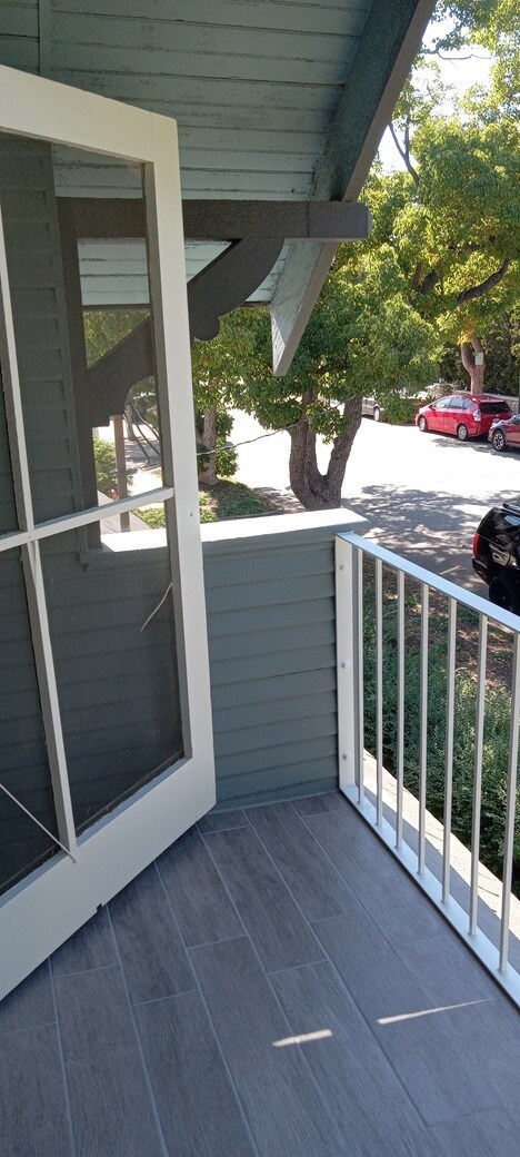 Upstairs porch with sitting area and electrical outlets. - 1135 Magnolia St