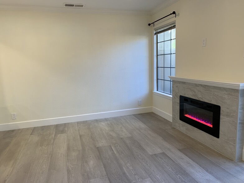 Living room with electric fireplace and engineered wood floor - 1908 Huxley Ct