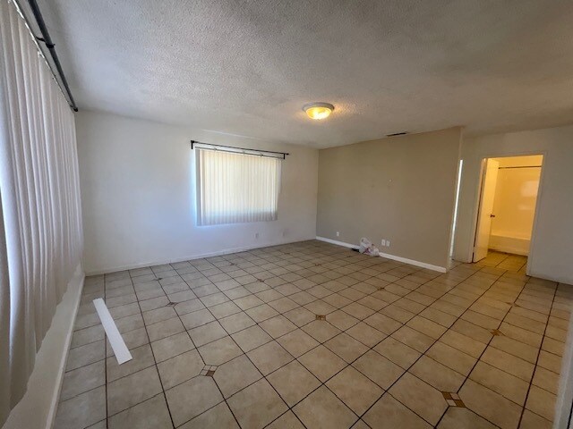 large living room with tile flooring lots of lighting - 101 E Olive Ave