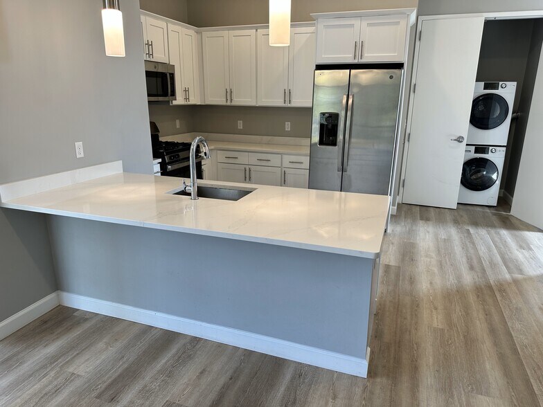 Tasteful galley kitchen w/quartz breakfast bar, SS appliances & wood cabinets - 271 Millburn Ave
