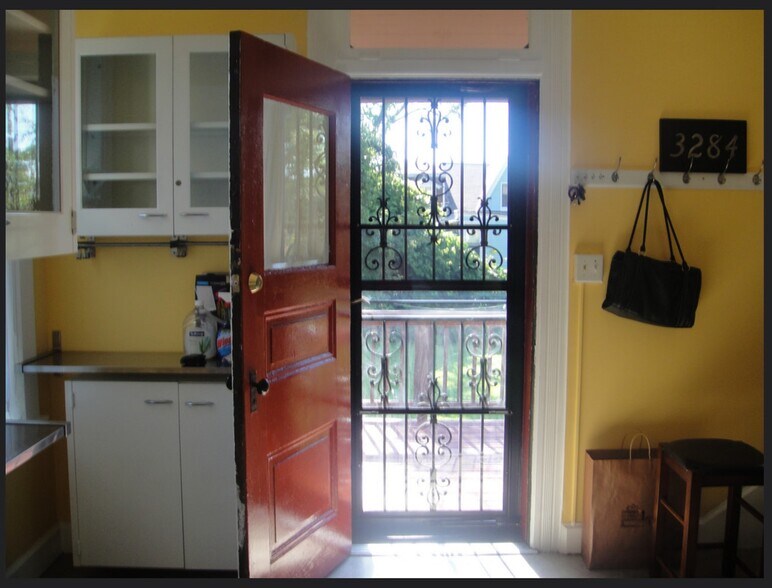 Kitchen entrance looks out over a small porch deck and back yard - 3284 Dawson Street