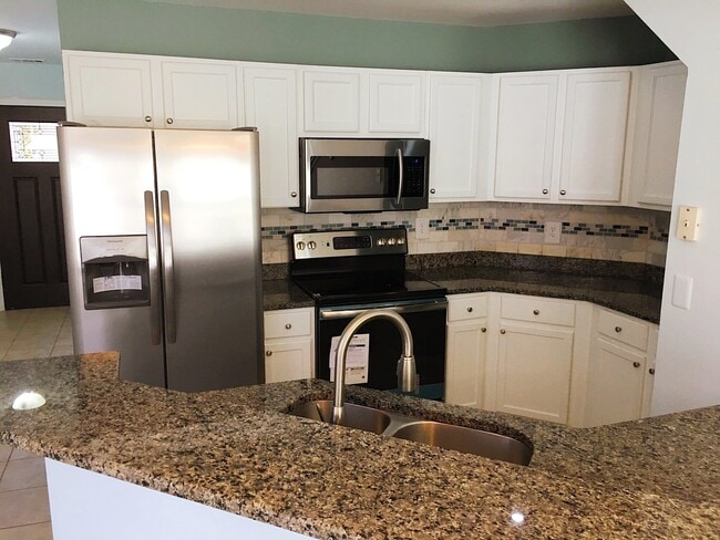 A kitchen with granite countertops, brand new appliances and paint - 190 Hutchinson St NE