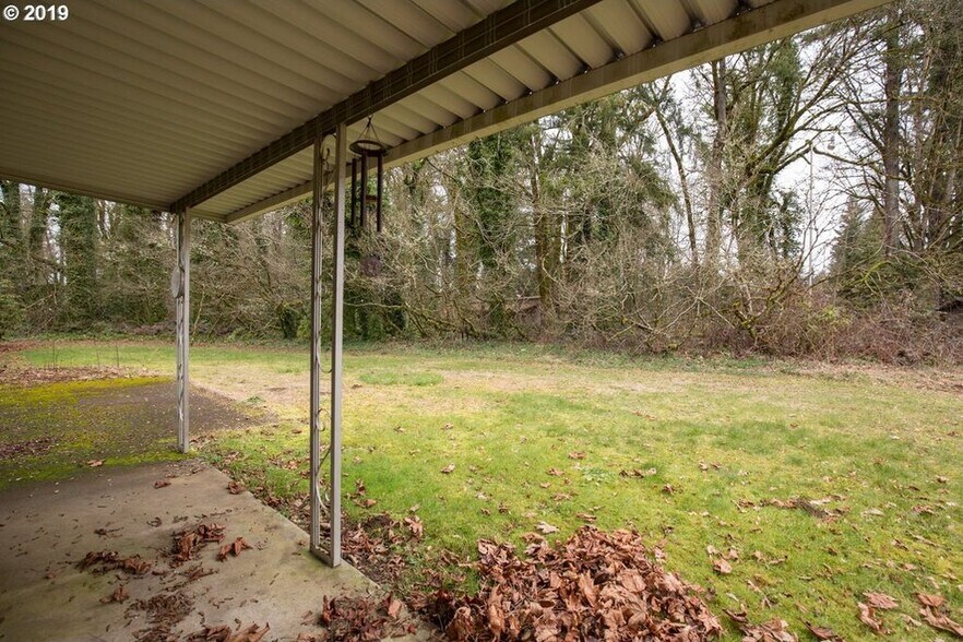 Covered patio and back yard looking into treed property - 13512 NE 238th Way