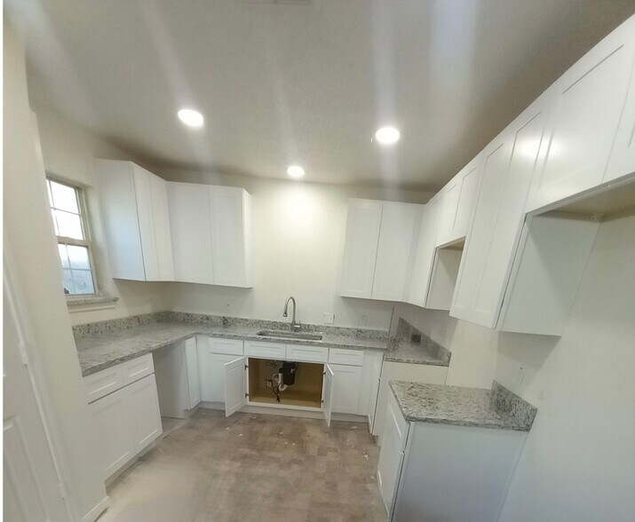 Open-concept living area and kitchen. This is your view from the living room. Ample white cabinetry. - 4720 Burma Rd