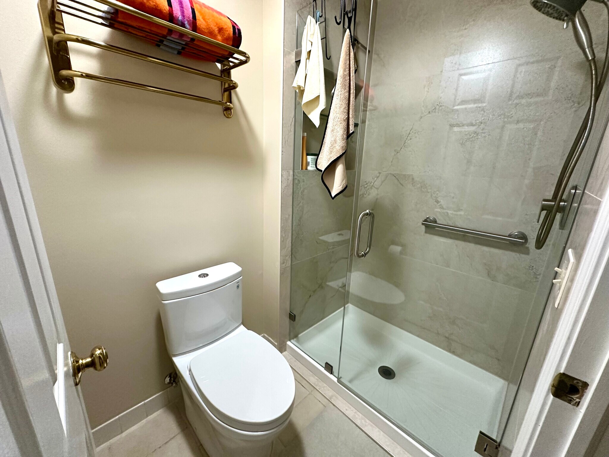 Swinging glass door, porcelain tiled shower to the ceiling, dual flush skirted toilet. - 174 Hemingway Ct