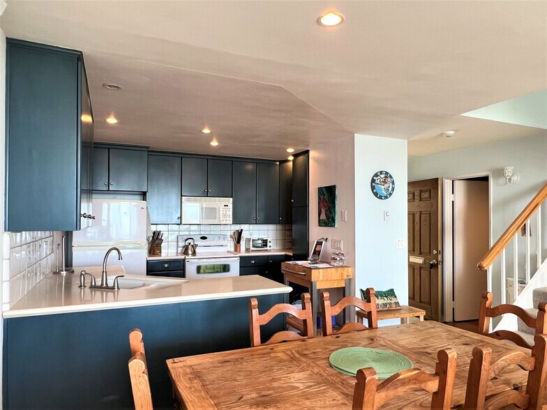 Kitchen facing front entry and half bath. - 665 The Village