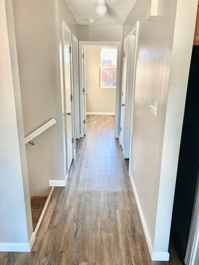 Upstairs hallway looking into back bedroom next to stairs going down - 1080 Fairlane Ct