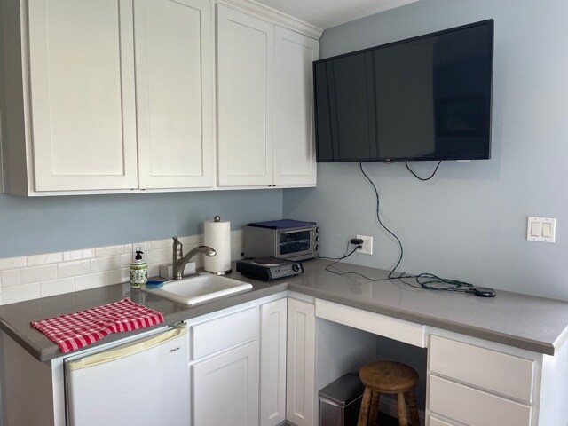 Small kitchen area with a hot plate, toaster oven, and small fridge - 11043 Lindblade St
