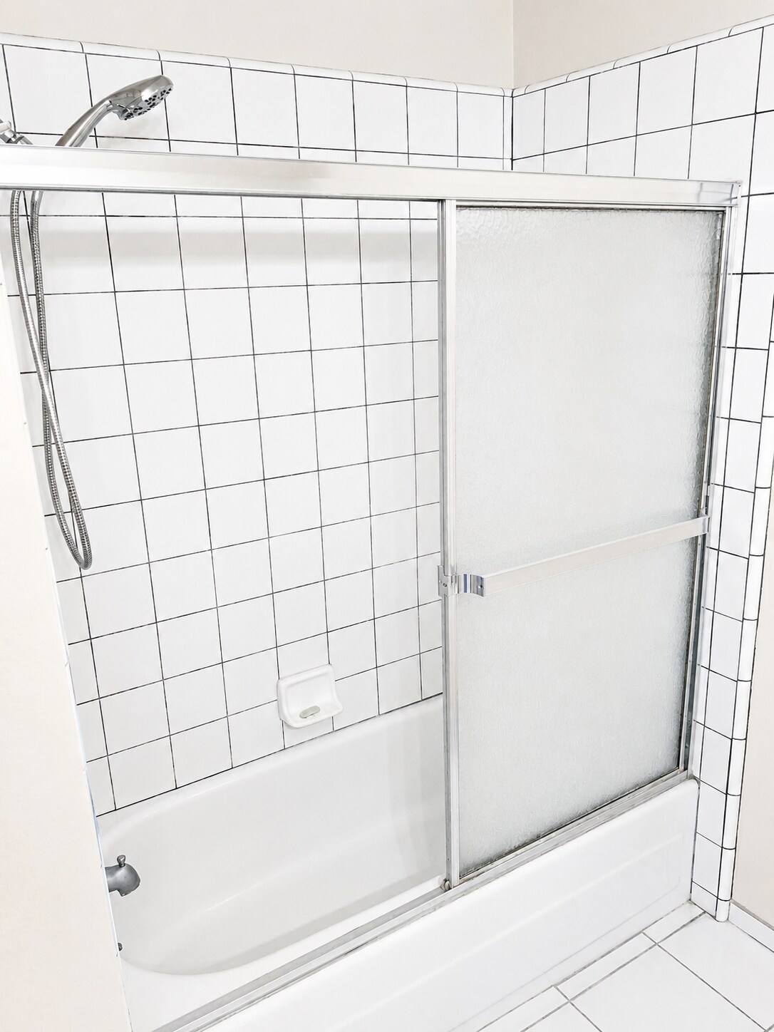 Second bathroom with tub/shower combo, tile surround, and sliding glass shower door. - 339 E Taft Ave
