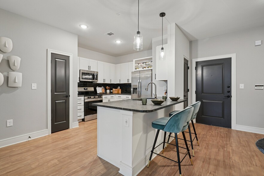 Kitchen with Granite Countertop and Stainless Steel Appliances. - Linz Charlotte