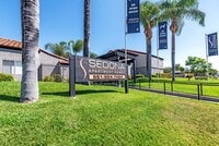 Sedona Apartments in Moreno Valley welcomes you with a modern, inviting entrance framed by lush landscaping and stylish, well-lit pathways. - Sedona Apartment Homes