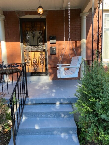 front door and relaxing polywood porch swing - 2918 N Gaylord St
