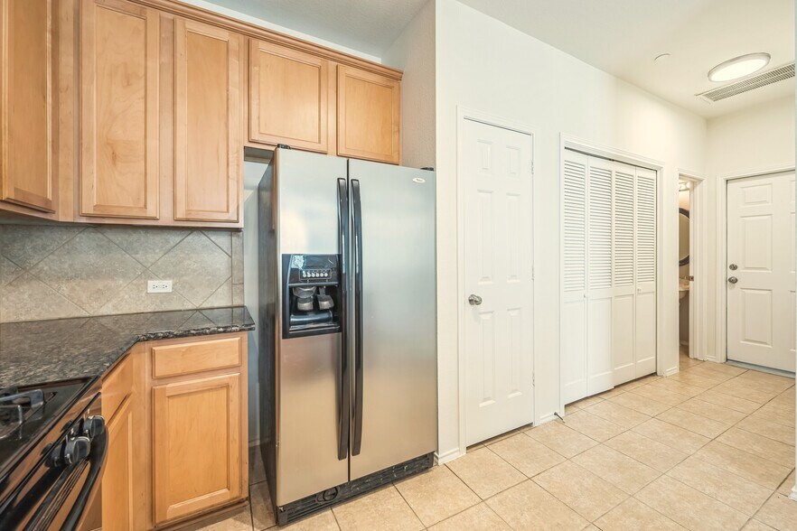 Kitchen and hallway to powder room and garage - 9201 Brodie Ln