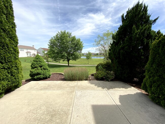 Backyard with access to neighborhood walking trail and view of the pond - 14295 Chariots Whisper Dr