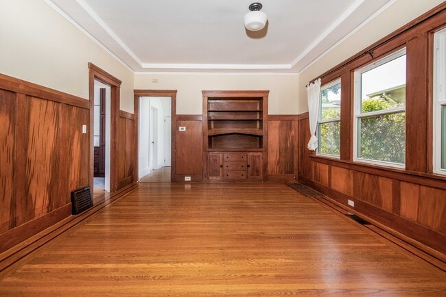 Dining room with wood-paneled walls, built ins, and natural light. - 431 Athol Ave