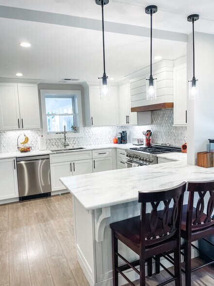 Peninsula kitchen with marble countertops. High end appliances and custom backsplash - 303 Woodland Shores Rd