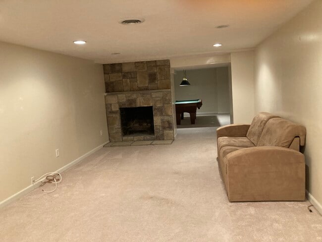 Family room on the lower level with stone fireplace and a pool table - 3065 Shelley Lynn Dr