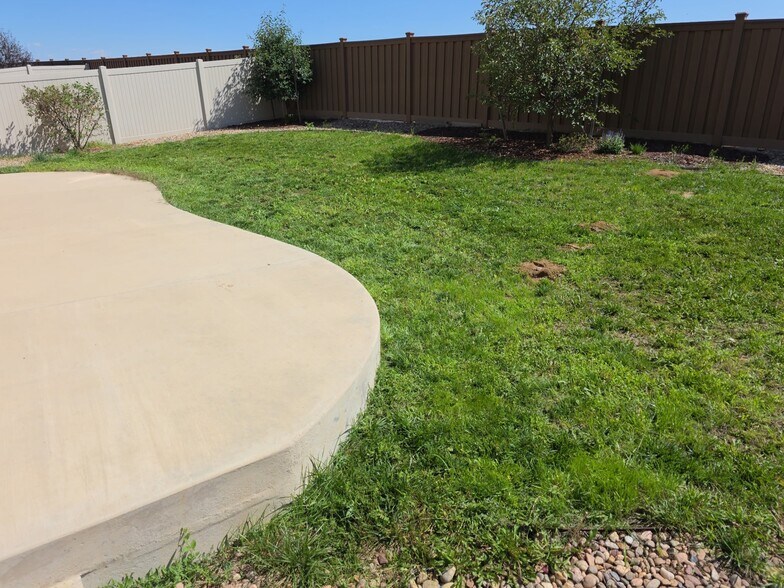 Landscaped yard with sprinkler system and oversized 30x15 concrete patio. - 17778 E 44th Ave