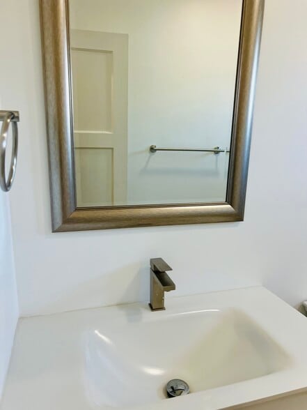Newly remodeled bathroom featuring a rain shower head, modern finishes, and a framed vanity mirror - 3551 W Manchester Blvd