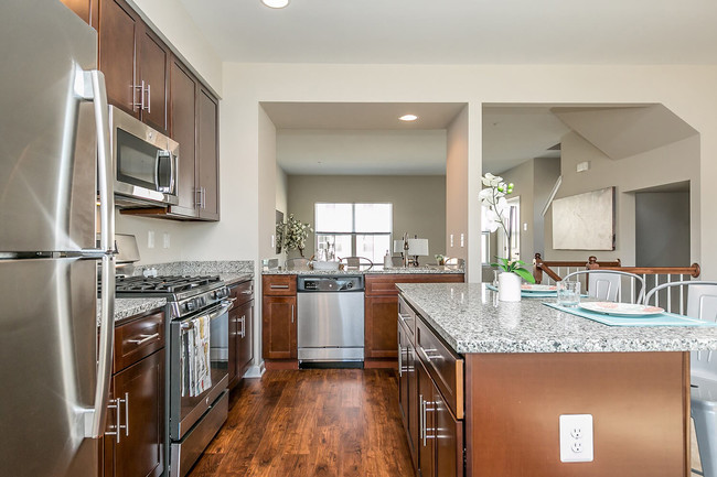 Beautiful, gourmet kitchens featuring granite, stainless steel appliances including gas range - Townes at Pine Orchard