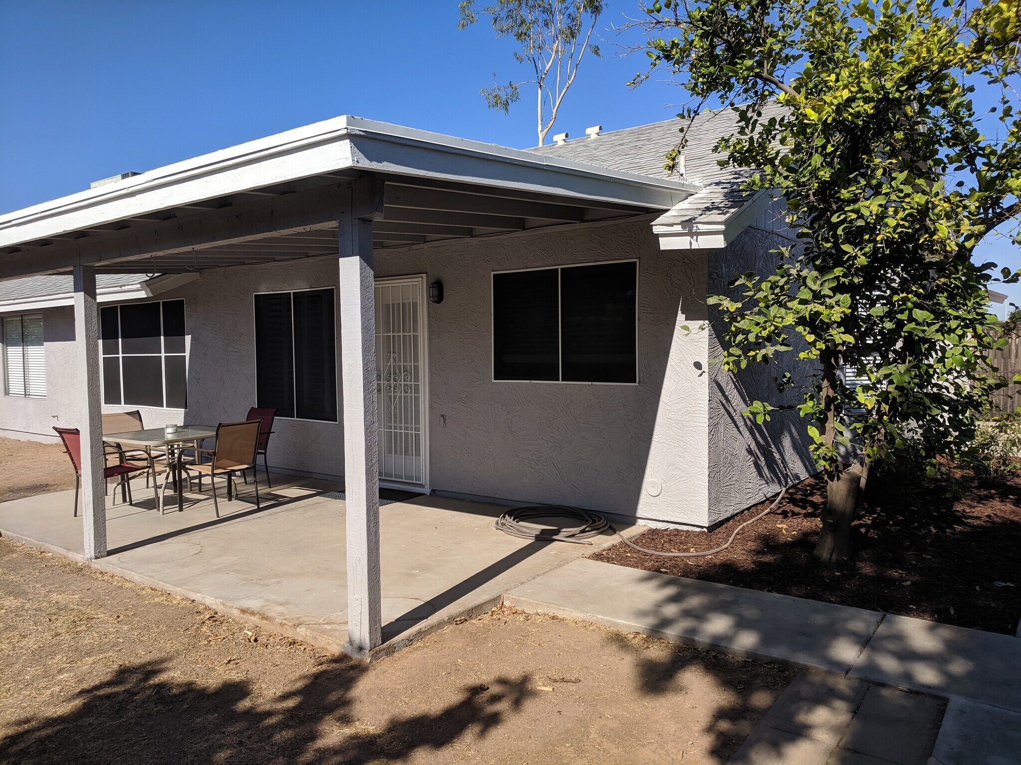 Facing back patio with security screen door, kitchen window, with solar screens - 14101 N 78th Dr