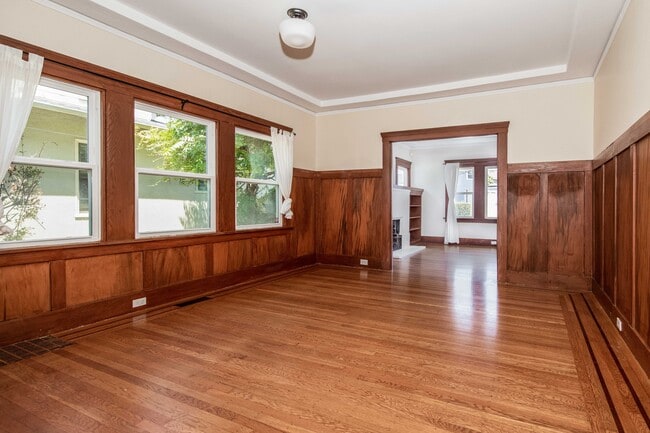 Dining room with wood-paneled walls, built ins, and natural light. - 431 Athol Ave