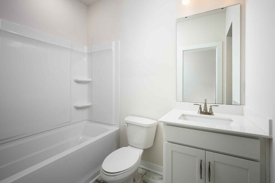 Private secondary bathroom with sleek quartz vanity and contemporary finishes. - 1421 Lithium Ln