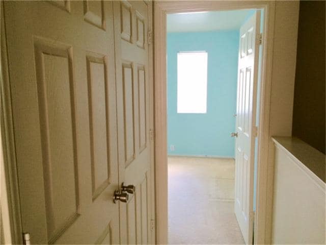 Hallway connecting two master bedrooms. Doors on left are convenient laundry location. - 23619 Twisting Falls Drive