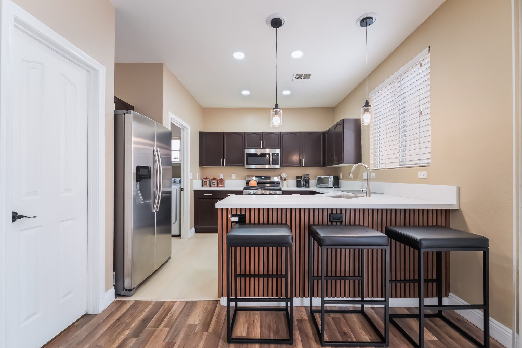 Kitchen with stainless steel appliances, a kitchen bar, hanging light fixtures, light wood-style flo - 1179 Antoinette St