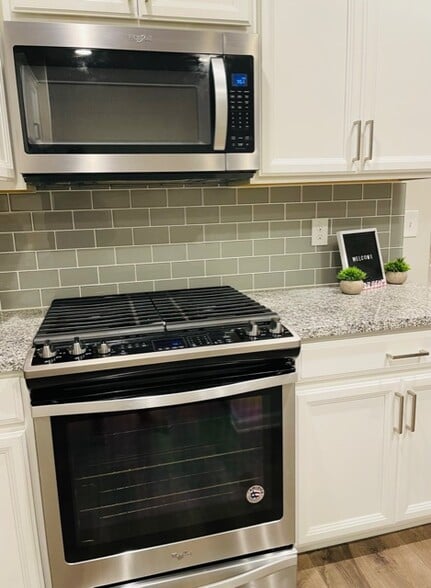 New stainless steel appliances include a backless gas stovetop and oven, as well as a microwave - 6126 Centennial Run