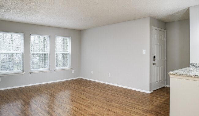 Spacious central living room with wood plank flooring - Burke Shire Commons Apartments