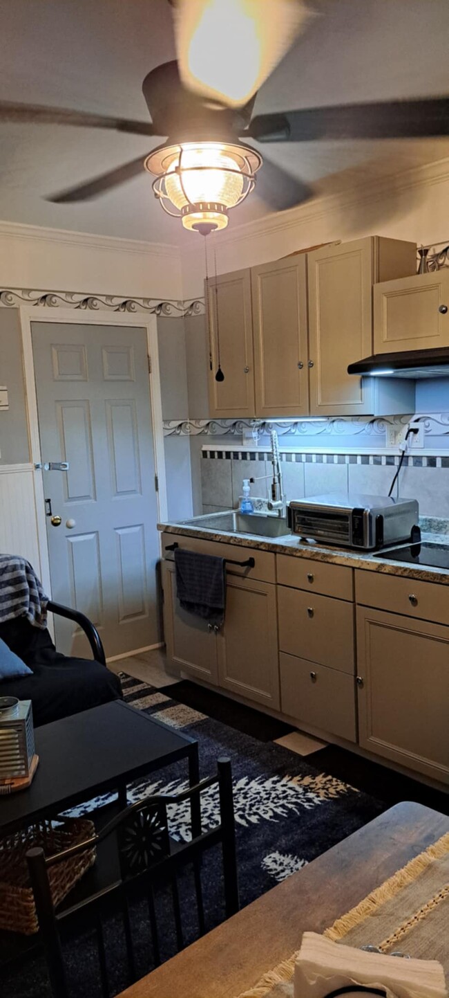 A small kitchen that includes dishes and pots and pans. - 903 Shem Creek Cir