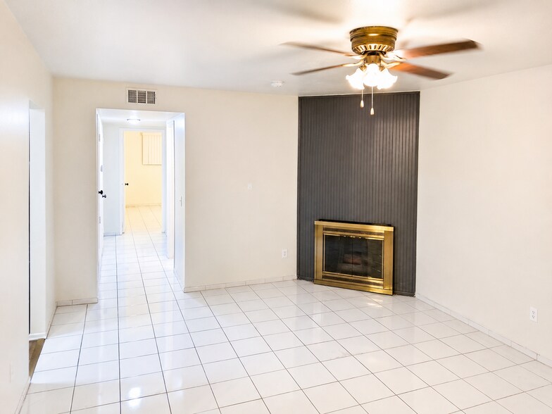 Spacious living room featuring a decorative fireplace, neutral walls, tile flooring, and a comfortab - 339 E Taft Ave