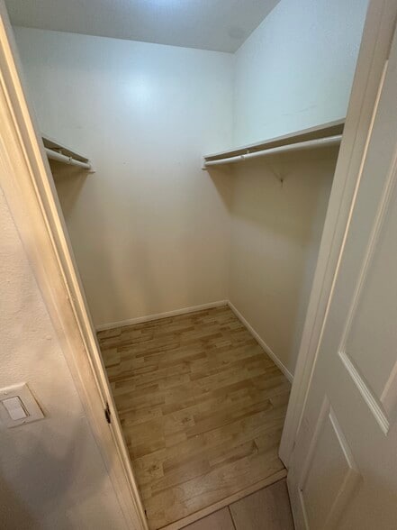 Primary walk in closet with additional double mirrored closet and linen cabinets - 22865 Del Valle St