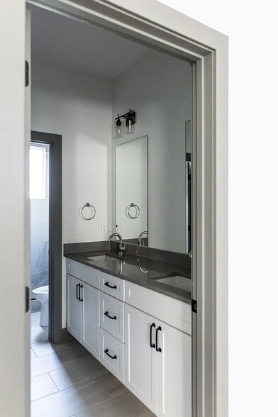 Primary Bathroom with dual sink vanities, a walk-in closet, and a stand up shower - 3505 S Marion St