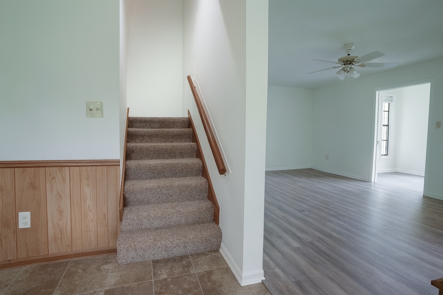 Carpeted staircase near kitchen and nook, bright with natural light and open flow. - 2313 Salem West Dr