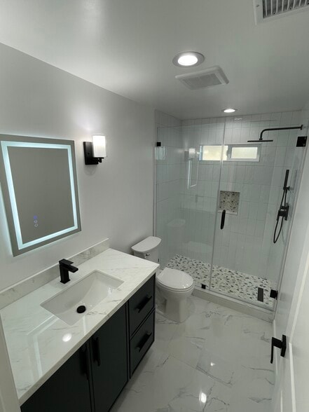 Fully updated bathroom featuring a walk-in glass shower, custom tile work, LED mirror, modern vanity - 327 Aliso St