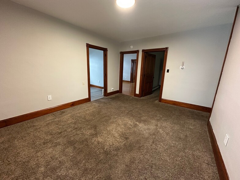 main living room - view from window. Doorways to kitchen and two bedrooms. - 115 E High St