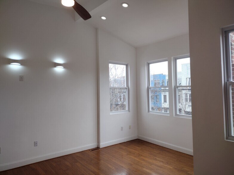 Primary Bedroom Expansive primary bedroom featuring five large windows that flood the space with nat - 1933 4th St NW