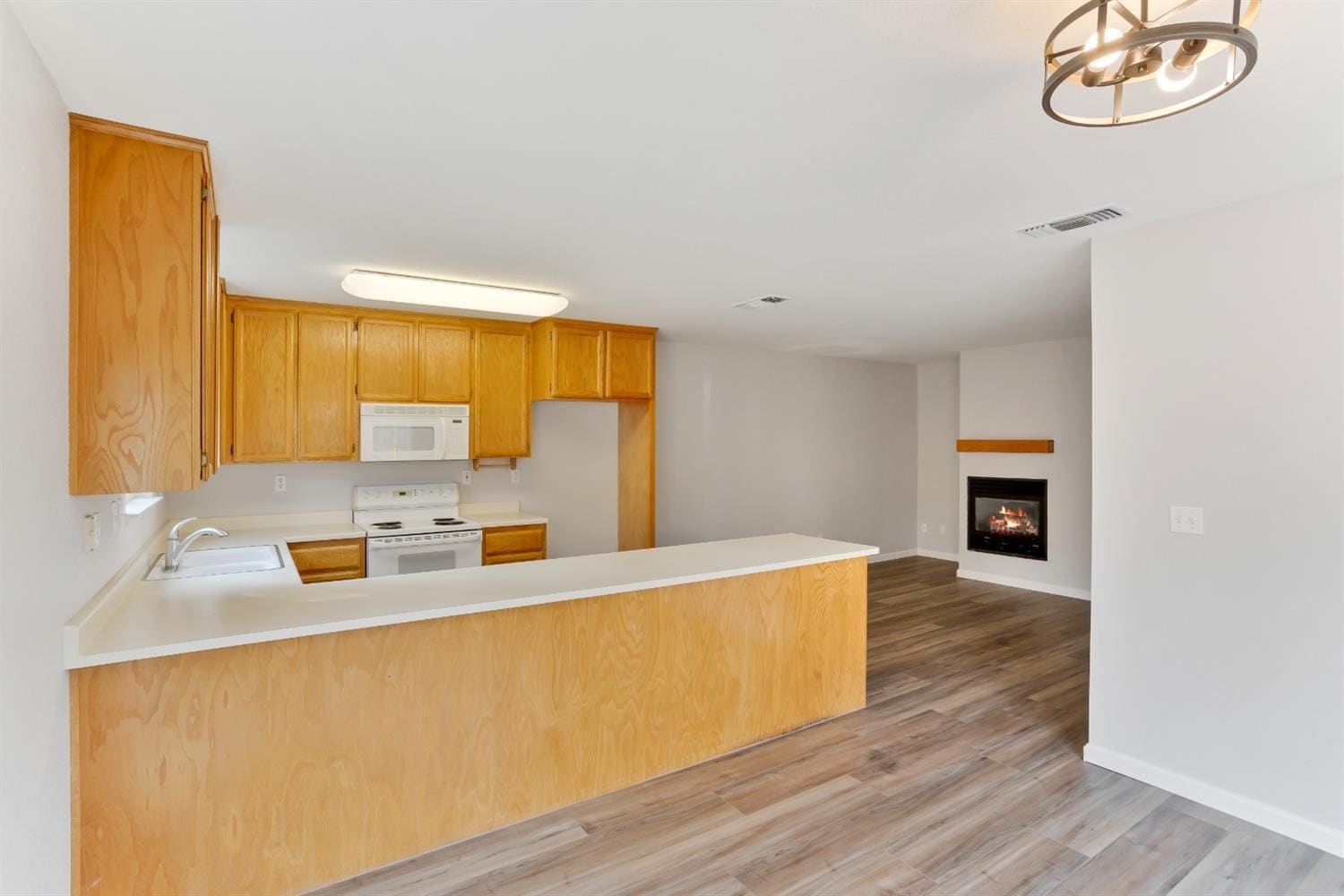 The view of the kitchen & family room from the dining room. - 3038 Courtside Dr