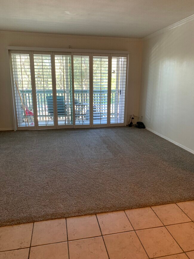 Living room with plantation shutters and new white vinyl double paned sliding glass doors - 436 N Bellflower Blvd