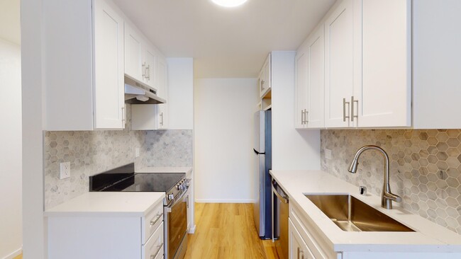 Kitchen with multiple cabinets, refrigerator, stove, range hood, and sink - 2627 Hillegass Avenue