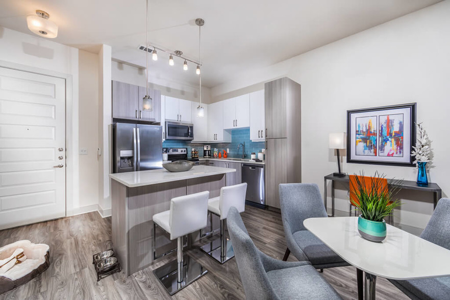 Mist kitchen design package with blue backsplash, tuxedo style cabinets in polished white and gray - Inwood Station Apartments