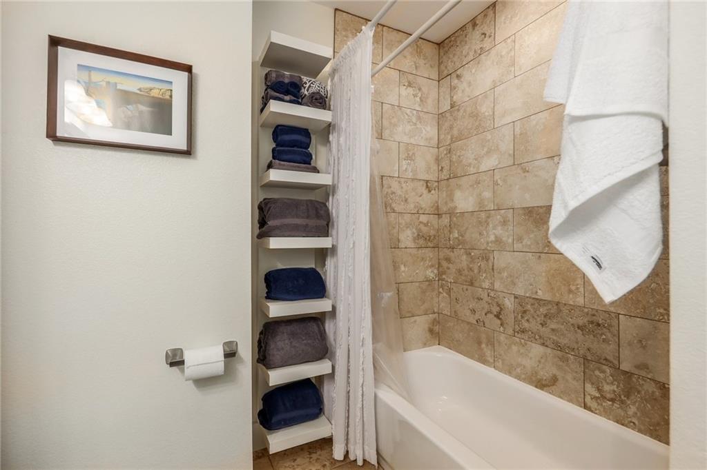 The guest bathroom also features built-in storage for towels, as well as a shower/bath combo. - 909 Reinli St